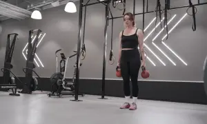 Tjej med kettlebells i gym, redo för sitt träningsschema.