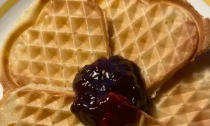 Hjärtformade veganska våfflor med en klick mörkt sylt. Perfekt för en mysig fika.