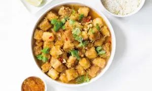 Krispig tofu i ugn med en smakrik sås, toppad med koriander och chili. Serveras med ris och lime.