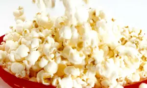 En röd korg fylld med fluffiga, luftpoppade popcorn. En härlig syn för alla popcornälskare!