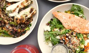 Två proteinrika sallader, en med kyckling och en med lax, samt en röd dryck. Perfekt för att få rätt mängd protein per kilo kroppsvikt.