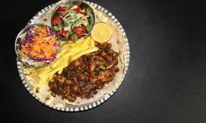 En stor portion kebabpizza med pommes frites, sallad och citron. En rejäl måltid, men tänk på kebabpizza kalorier!