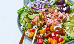 En fräsch sallad med lax, avokado, tomat, gurka, rödlök och fetaost. Ett perfekt medelhavskost recept för en lätt lunch.