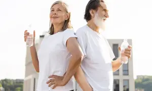 Ett äldre par med vattenflaskor, redo för träning. Bra tips gå ner i vikt för alla åldrar.