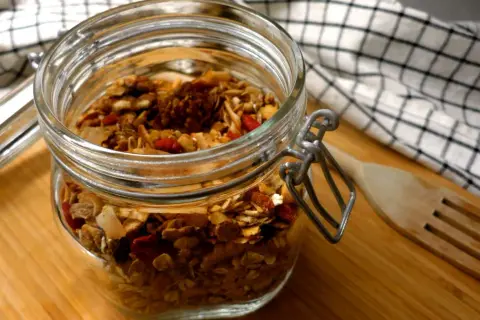 Burk med hemgjord granola, full av nötter och torkad frukt. Perfekt för nyttiga snacks!