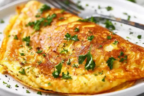 En gyllene, fluffig omelett toppad med färsk persilja. En perfekt och nyttig omelett för en snabb frukost eller lätt lunch.