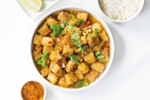 Krispig tofu i ugn med en smakrik sås, toppad med koriander och chili. Serveras med ris och lime.