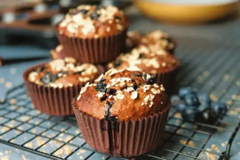 Nyttiga frukostmuffins med blåbär och havregryn på ett galler. Perfekt start på dagen!