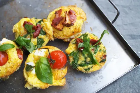 Små omelettmuffins med tomat, spenat och bacon. Perfekt nyttig sommarmat för en lätt lunch eller frukost.