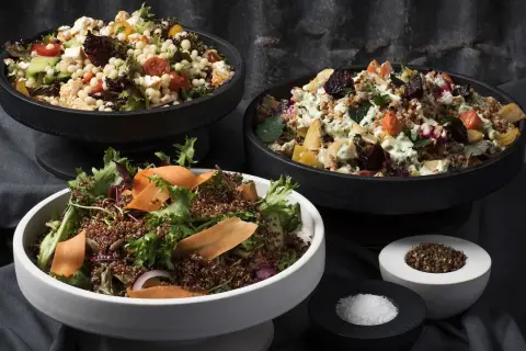 Tre skålar med nyttiga sallader: en med couscous, grönsaker och fetaost, en med rotfrukter och en med quinoa och grönt.