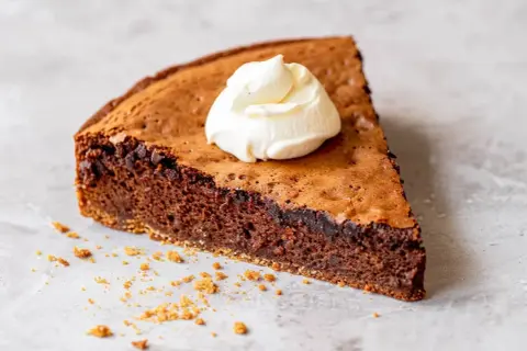 En bit chokladkaka med vispad grädde, perfekt för att baka med proteinpulver för en nyttigare dessert.