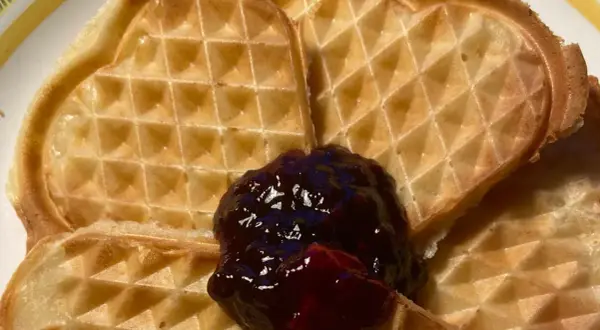 Hjärtformade veganska våfflor med en klick mörkt sylt. Perfekt för en mysig fika.