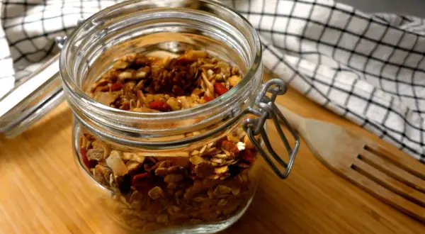Burk med hemgjord granola, full av nötter och torkad frukt. Perfekt för nyttiga snacks!