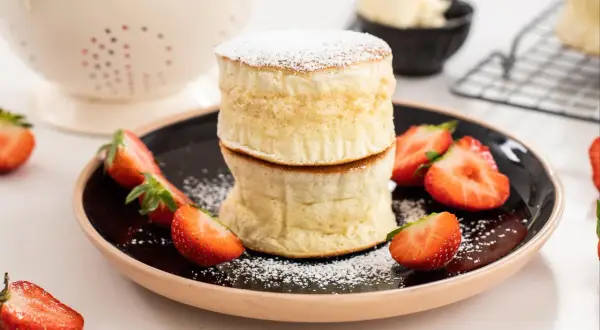 Fluffiga proteinpannkakor med jordgubbar och pudersocker. Ett perfekt recept för en hälsosam frukost eller mellanmål.
