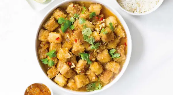 Krispig tofu i ugn med en smakrik sås, toppad med koriander och chili. Serveras med ris och lime.