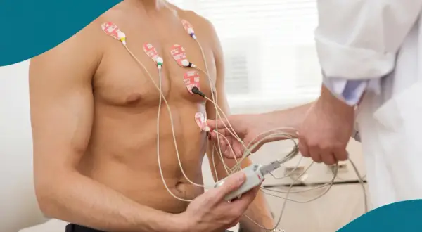 Man får EKG-elektroder fästa på bröstet för att mäta hjärtats hård puls.