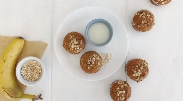Frukost muffins med havre och banan, serverade med ett glas mjölk. Perfekt start på dagen!
