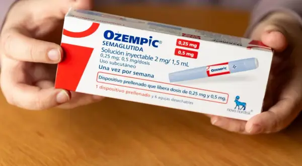 Händer håller i en kartong med Ozempic, som används för viktnedgång. Information om doser och biverkningar kan finnas på förpackningen.