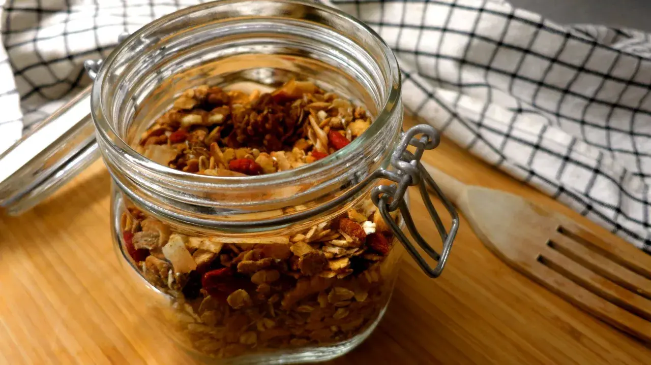 Burk med hemgjord granola, full av nötter och torkad frukt. Perfekt för nyttiga snacks!