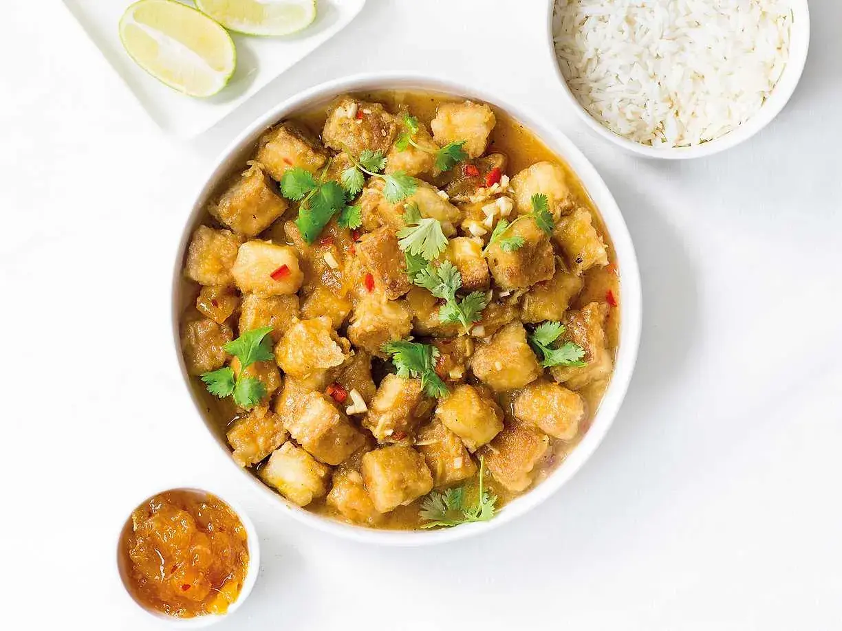 Krispig tofu i ugn med en smakrik sås, toppad med koriander och chili. Serveras med ris och lime.