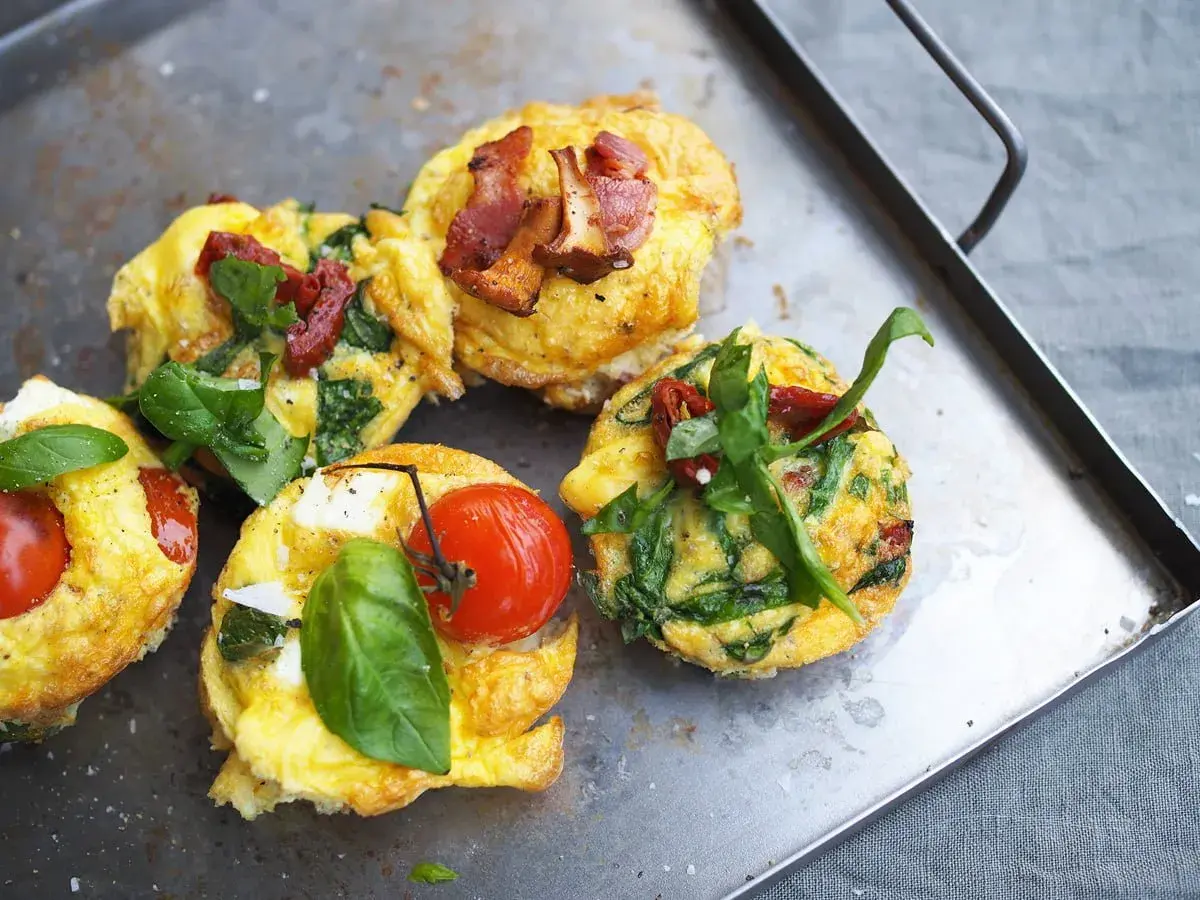 Små omelettmuffins med tomat, spenat och bacon. Perfekt nyttig sommarmat för en lätt lunch eller frukost.
