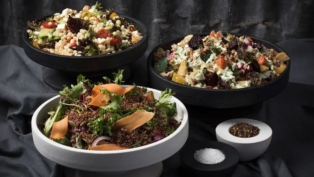 Tre skålar med nyttiga sallader: en med couscous, grönsaker och fetaost, en med rotfrukter och en med quinoa och grönt.