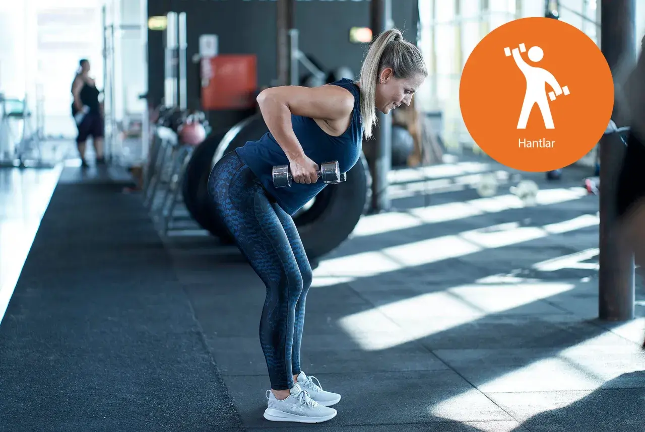 Kvinna utför rodd med hantlar, en övning som liknar floor press för ryggmusklerna.