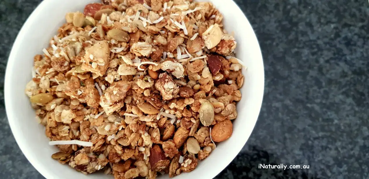 En skål med hemmagjord granola, full av nötter, frön och kokosflingor. Ett perfekt nyttigt granola recept för en energifylld start på dagen.