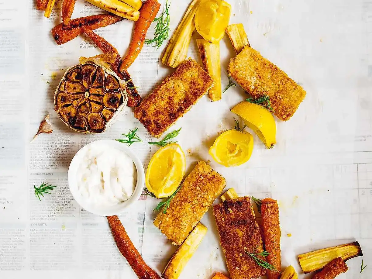 Ugnsbakad tofu i panering, serverad med rostade rotfrukter, citronklyftor, vitlök och en krämig dipp.