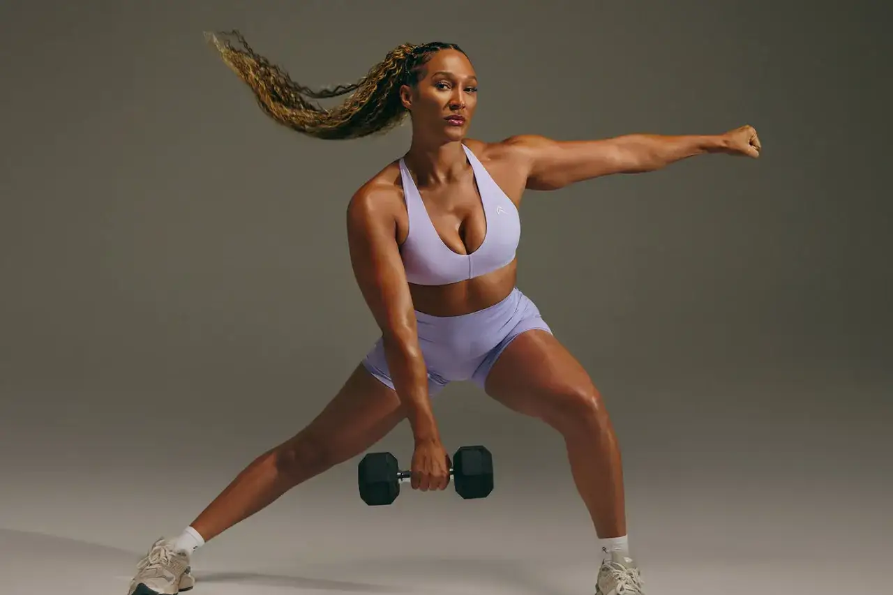 En stark tjej utför ett utfallssteg med hantel, en del av ett effektivt träningsschema gym.