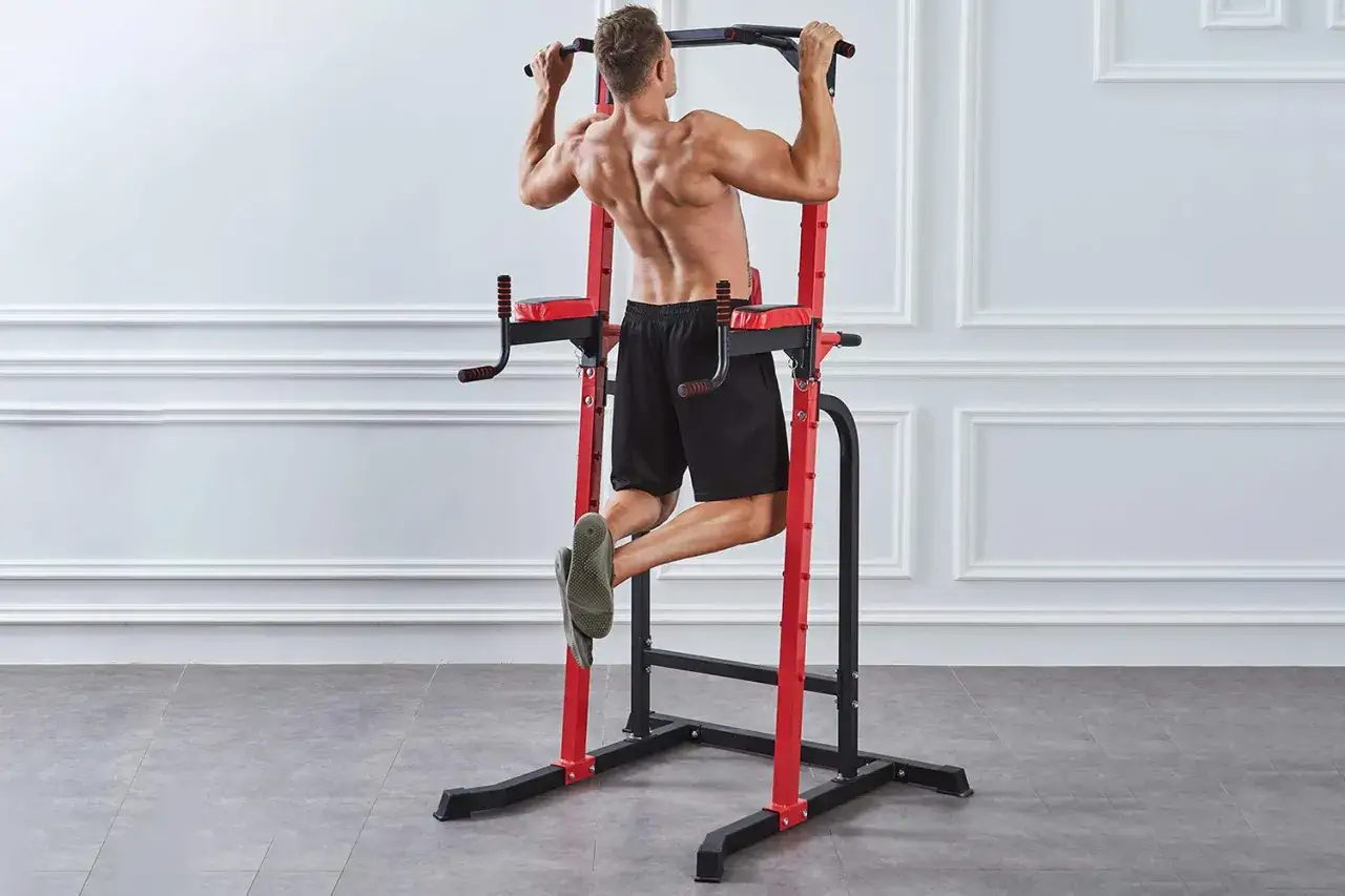 Man gör pull-ups på en träningsställning för att bygga muskler hemma.