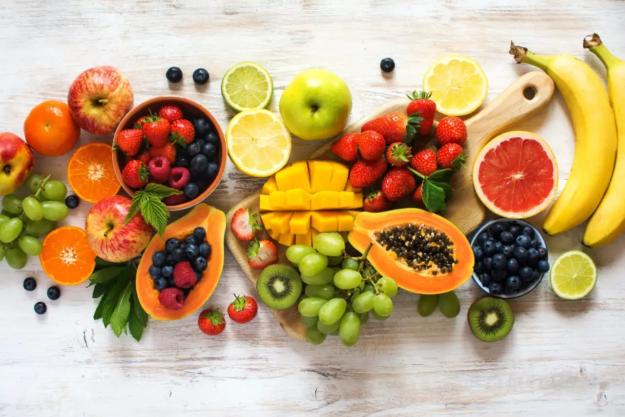 En färgsprakande samling av nyttigaste frukten: jordgubbar, blåbär, vindruvor, kiwi, mango, papaya, bananer, äpplen, apelsiner, citron och lime.