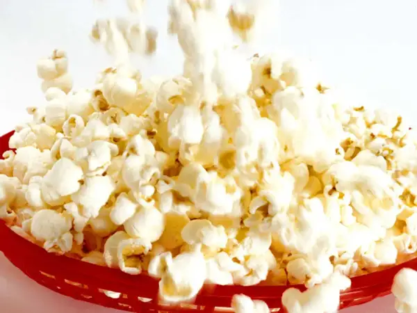 En röd korg fylld med fluffiga, luftpoppade popcorn. En härlig syn för alla popcornälskare!