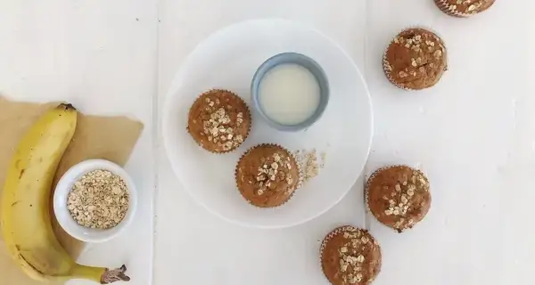 Frukost muffins med havre och banan, serverade med ett glas mjölk. Perfekt start på dagen!