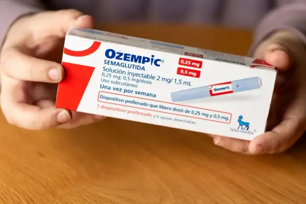 Händer håller i en kartong med Ozempic, som används för viktnedgång. Information om doser och biverkningar kan finnas på förpackningen.