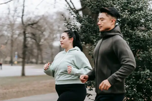 Ett par joggar utomhus, en del av deras resa för att gå ner i vikt utan att banta.